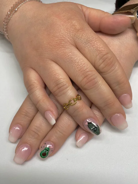 Manicura con degradado rosa y blanco y dibujos de un aguacate y un cactus.